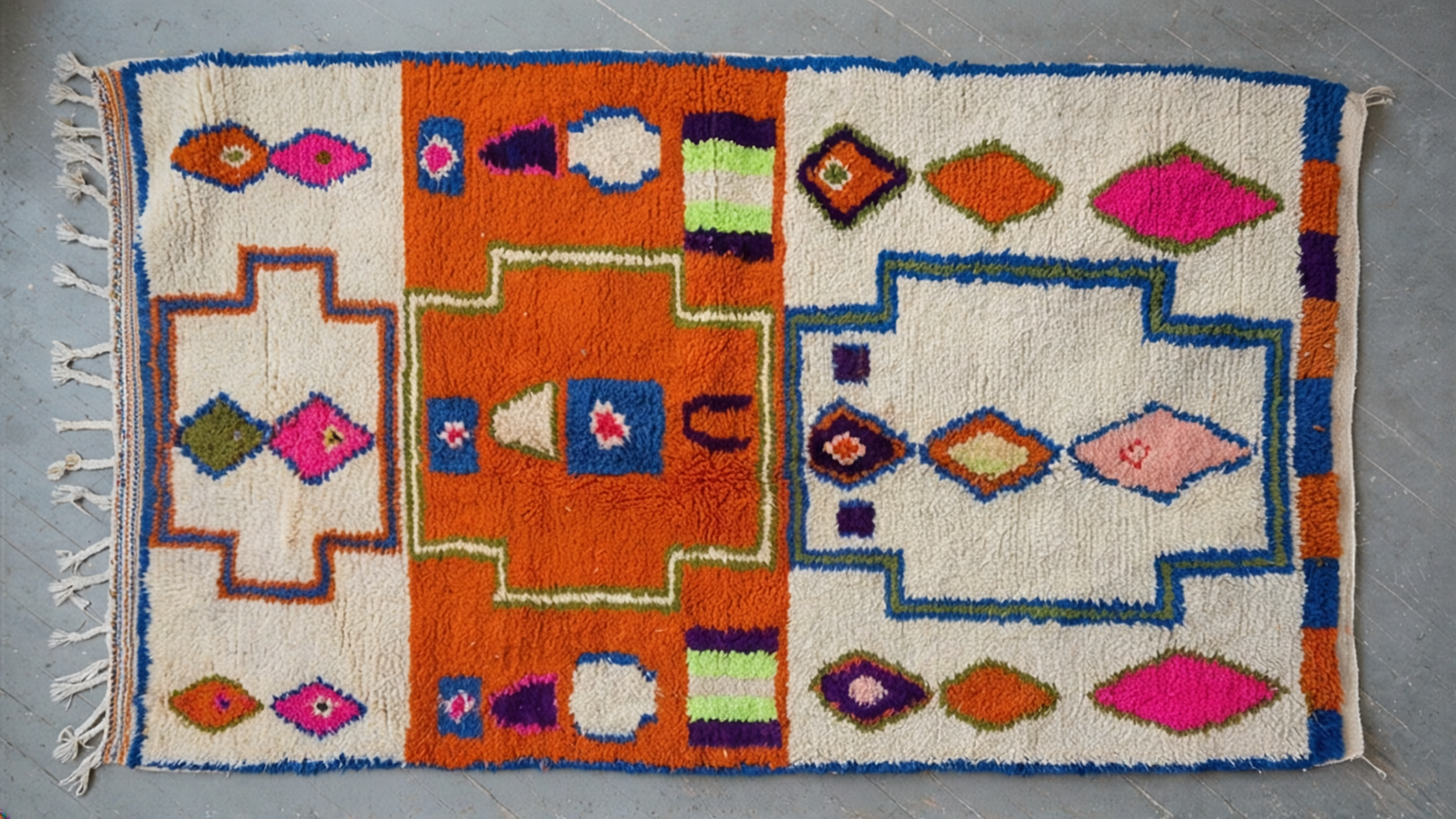 Zilka rug close-up showing vivid orange, pink and blue hand-knotted wool sections
